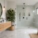 Modern white bathroom remodel featuring floating oak vanity, frameless glass shower and marble flooring